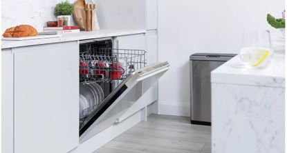 one of the best integrated dishwasher options in a white minimal kitchen with food and recipe books on the counter