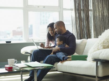 Family sitting on sofa shopping online