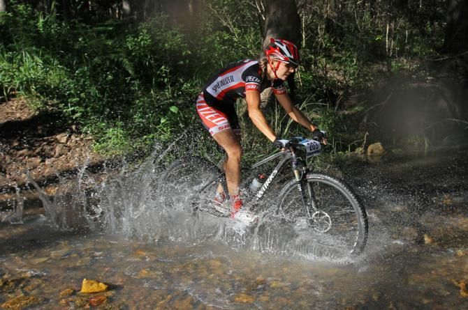 Race winner Jenny Fay croses a creek. Creeks were high after 85mm of rain in recent weeks.
