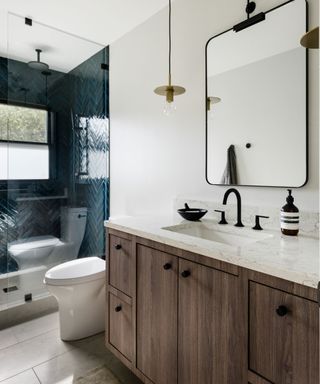 modern bathroom with white walls, wooden vanity and blue tiled shower