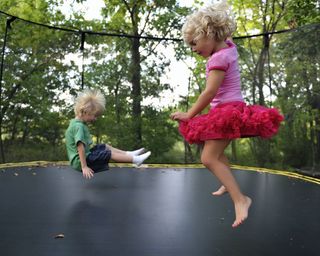 small children on trampoline in garden