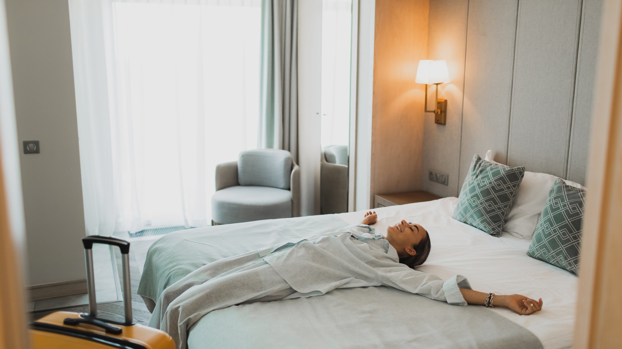 a woman relaxes on a plush bed in a contemporary hotel