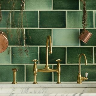 kitchen with green wall tiles and tap