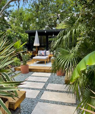 Backyard with tropical style plants, paving, decking with lounge