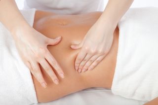 A close up of a woman getting her stomach massaged