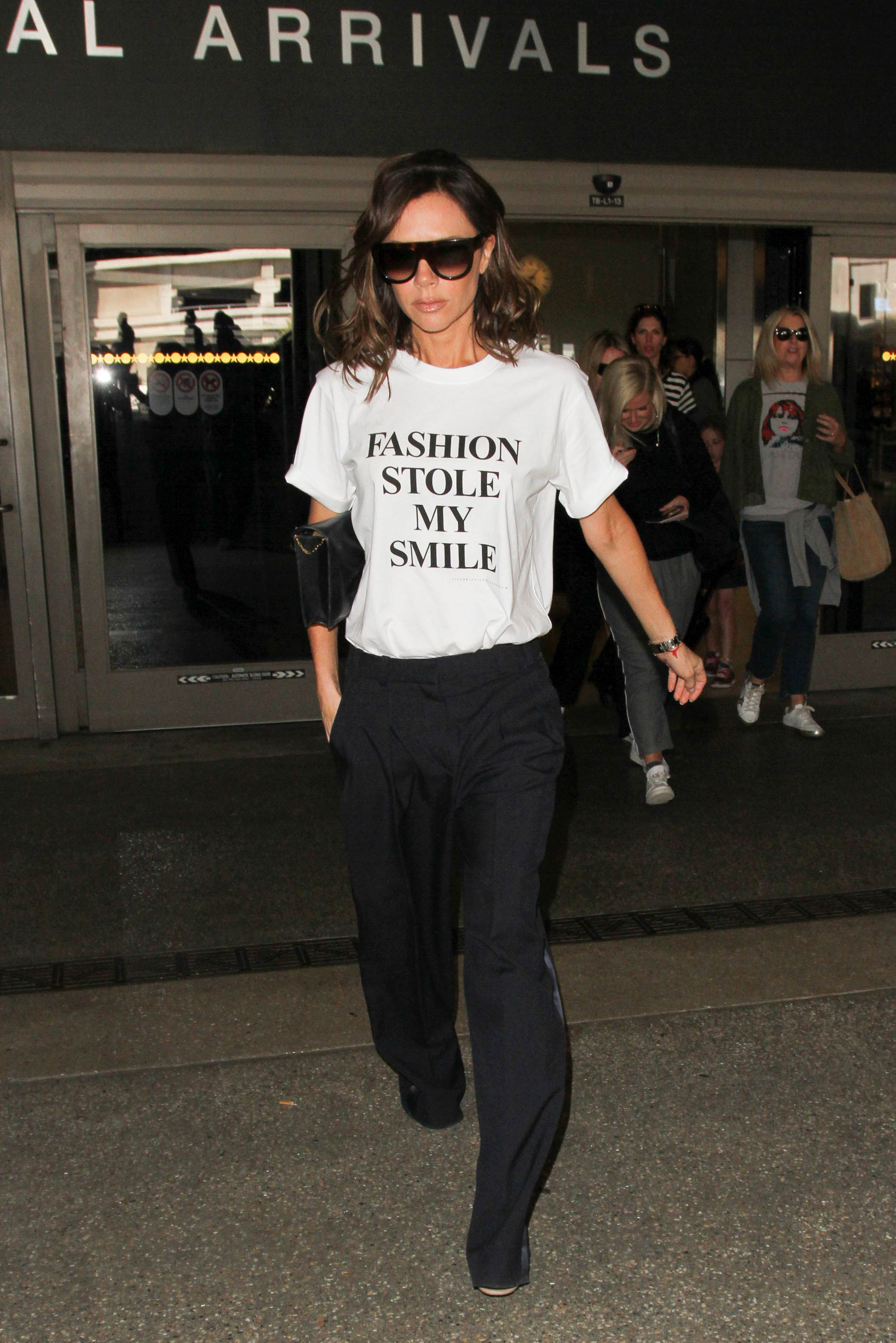 An image of Victoria Beckham wearing an iconic airport outfit while travelling in 2017.