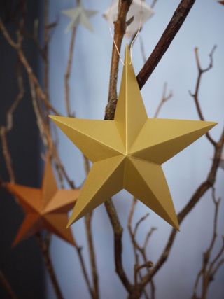 paper star garland with gold and copper stars hanging from branches