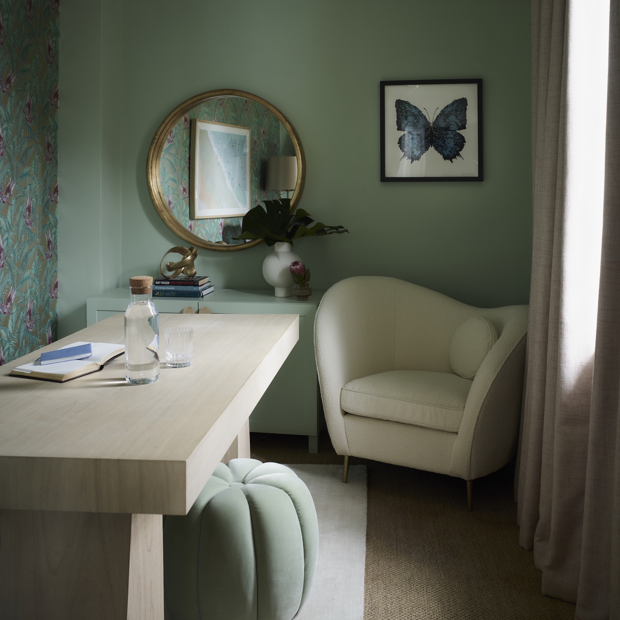 green painted home office with white desk and white armchair