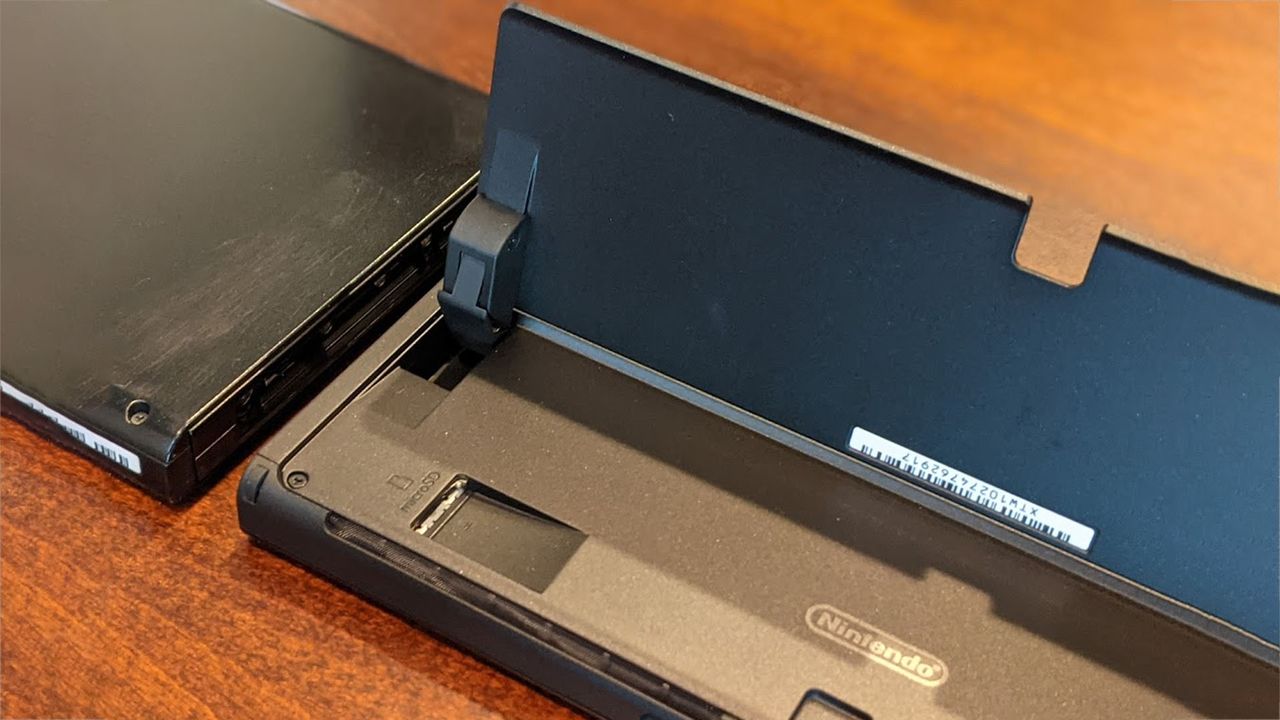 Nintendo Switch OLED with kickstand up and microSD card slot exposed.