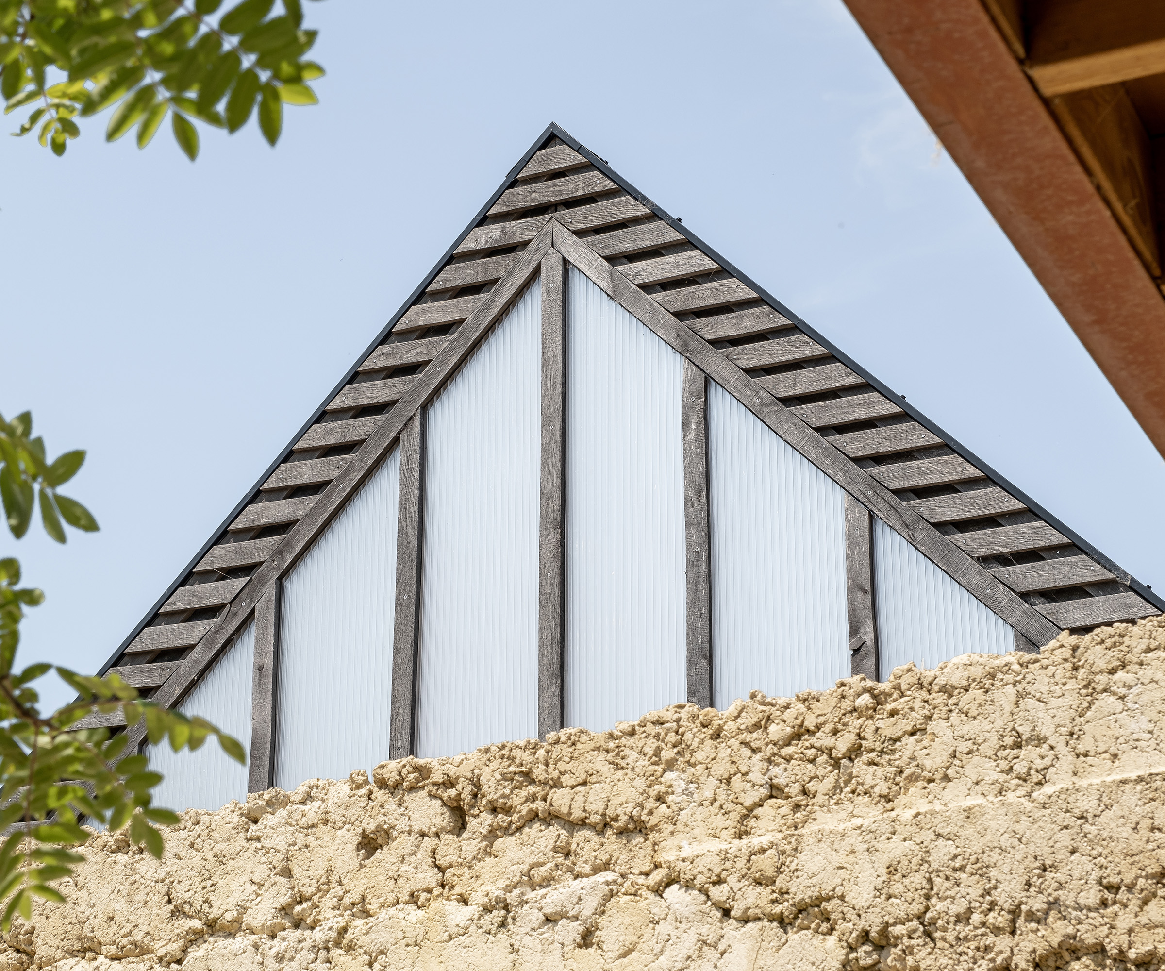 View of a pitched roof clad in timber with frosted gable glazing