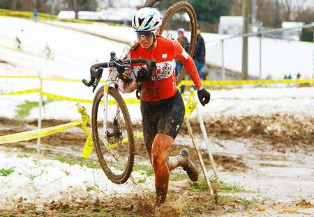 Ruby West (Specialized-tenspeed Hero) U23 Canadian Champion carries her bike threw some puddles