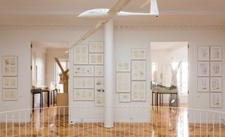 Interior displaying framed sketches, parquet floor and model glider