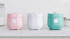 Best rice cooker. Three colorful rice cookers on kitchen countertop, gray and white kitchen