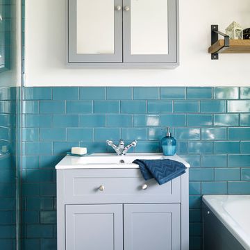 Teal blue bathroom makeover with patterned floor and grey furniture ...