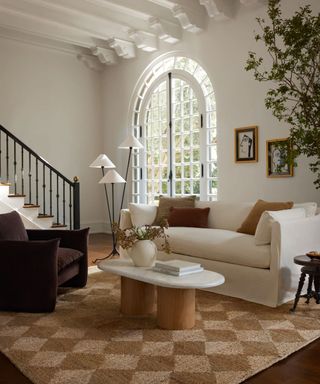 Living room with marble and wood coffee table, cream sofa and armchair