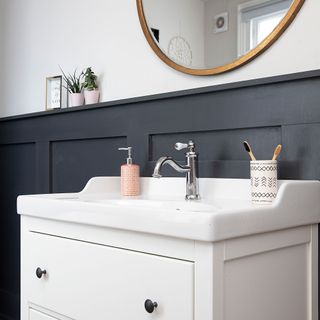 bathroom with grey wall panelling, white vanity unit with basin and chrome tap