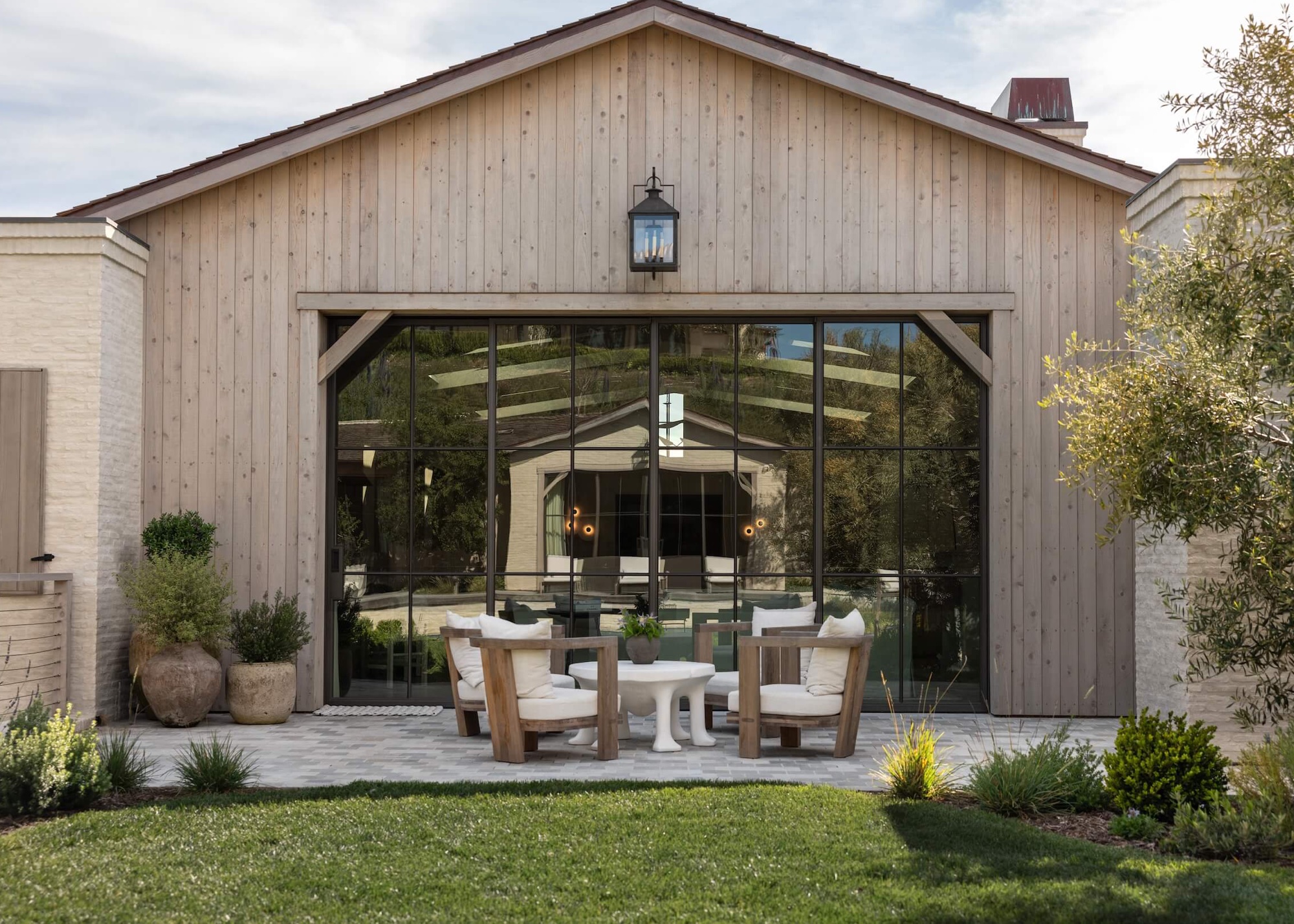 outdoor terrace with large terracotta planters and outdoor chairs with a table in the middle