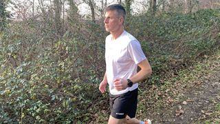 runner in white T-shirts and adidas Terrex Multi Trail Running Shorts running in leafy woods