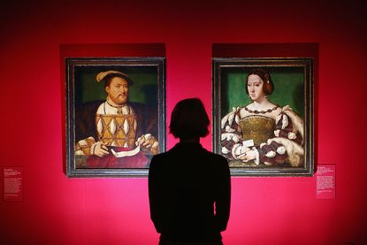 A woman admires paintings by Joos van Cleve entitled 'Henry VIII' (L) and 'Eleanora of Austria, Queen of France'.
