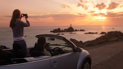 Couple looking at sunset in car