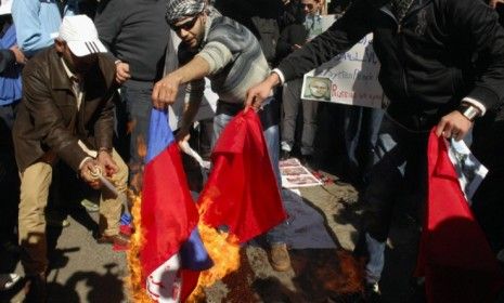 Syrian protesters living in Lebanon burn Chinese and Russian flags in Beirut on Sunday, after the two nations vetoed a U.N. resolution condemning Syrian President Bashar al-Assad&amp;#039;s regime.