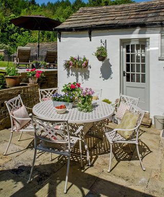 outdoor white table with cushions and flower pots