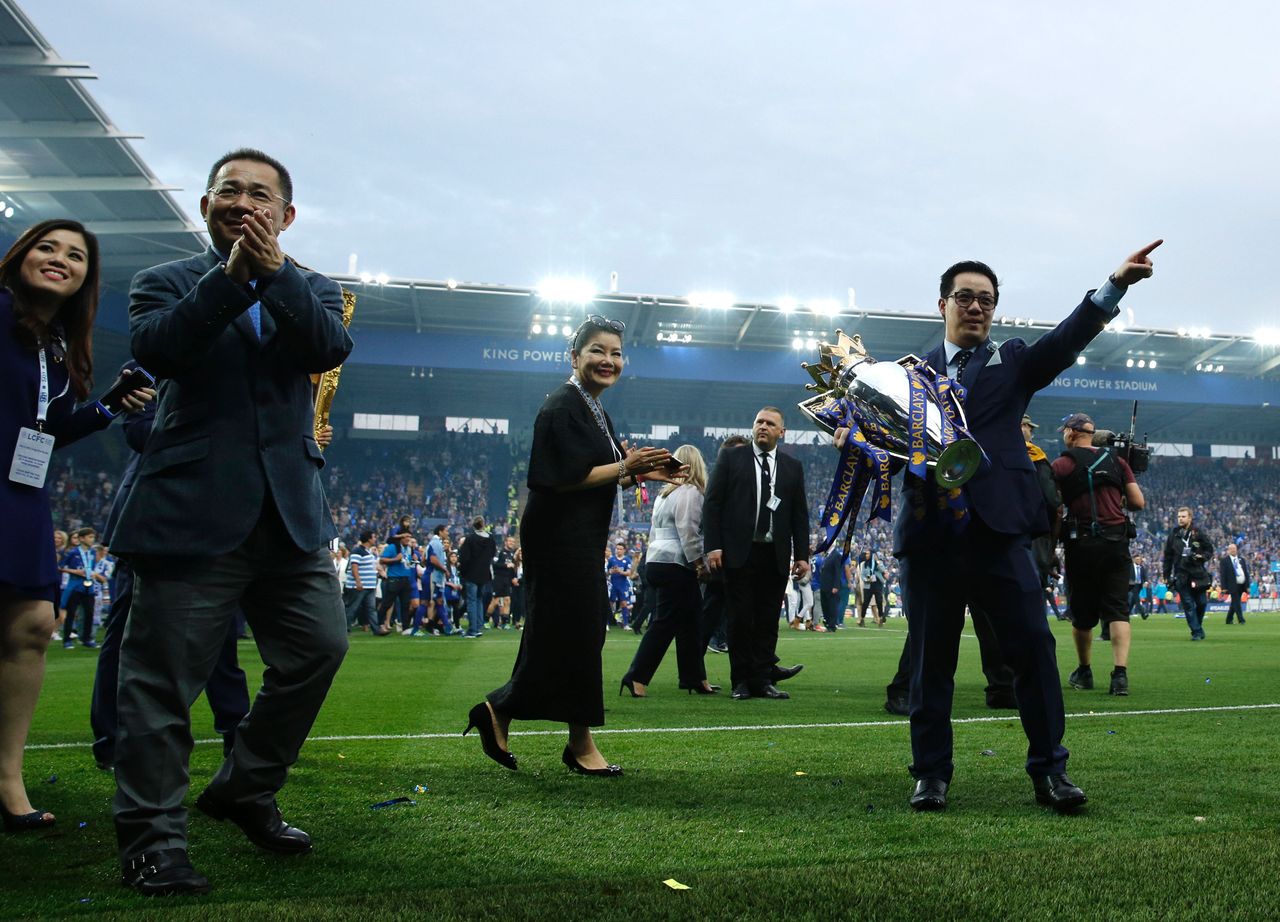 Leicester City's Thai chairman Vichai Srivaddhanaprabha (L) and his son Aiyawatt Srivaddhanaprabha (R) perform a lap of honour with the Premier league trophy after winning the English Premier