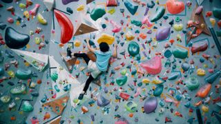 girl climbing a bouldering wall at a rock climbing gym