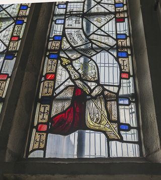 Lyddington: A detail of the bedchamber glazing showing the kneeling figure of a bishop, probably Bishop Alnwick, with his crozier