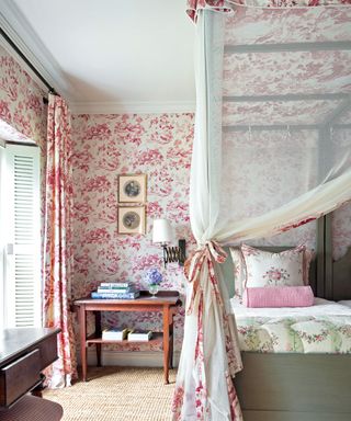 country style bedroom with four poster bed and pink toile wallpaper and curtains