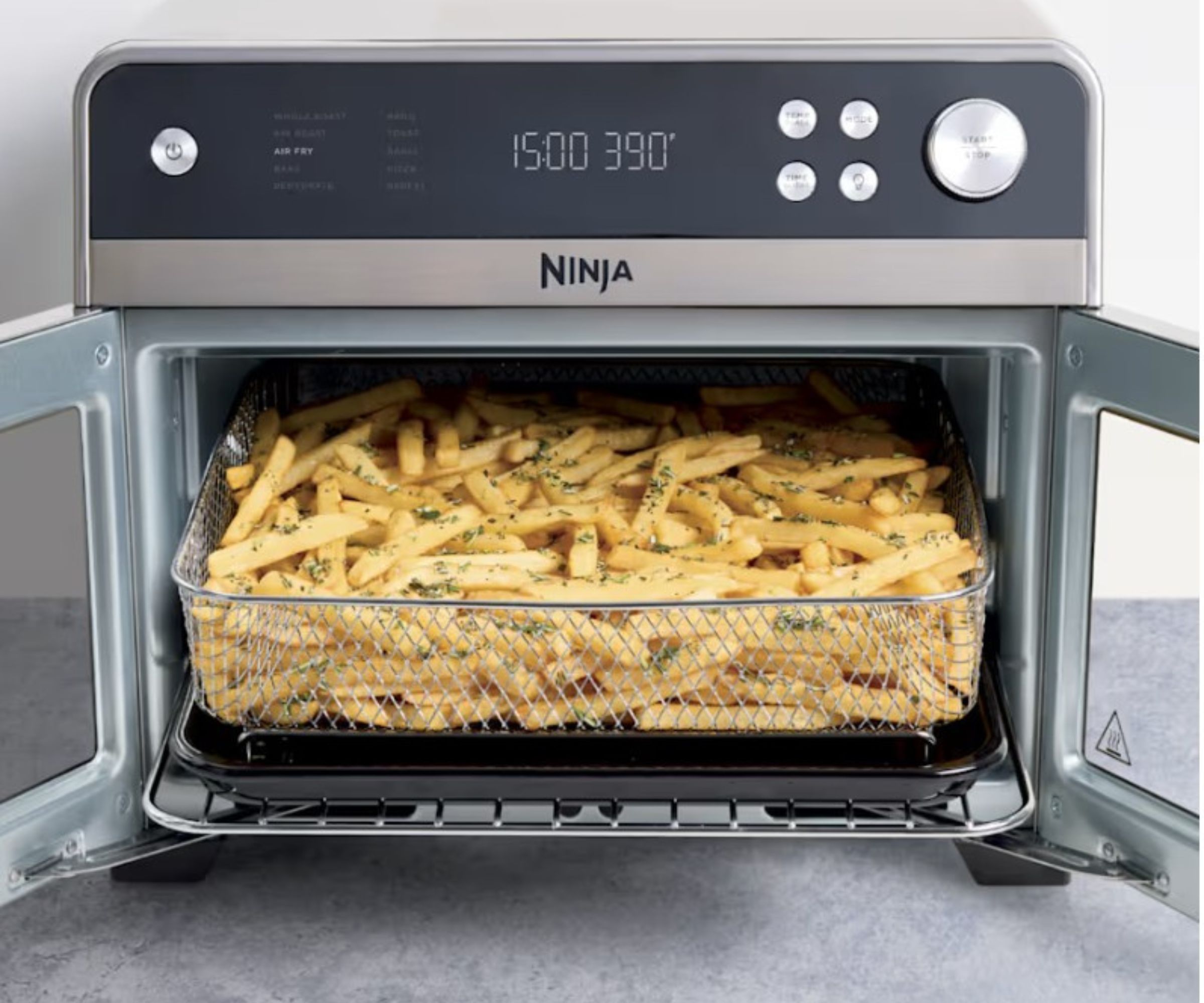 An open double-door air fryer with a basket of fries inside.