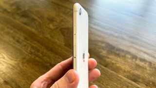iPhone SE 2022 in hand, side view