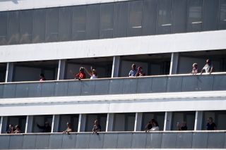 Passengers form Holland America&#039;s cruise ship Rotterdam cheer as they head to dock at Port Everglades in Fort Lauderdale, Florida, on April 2, 2020.