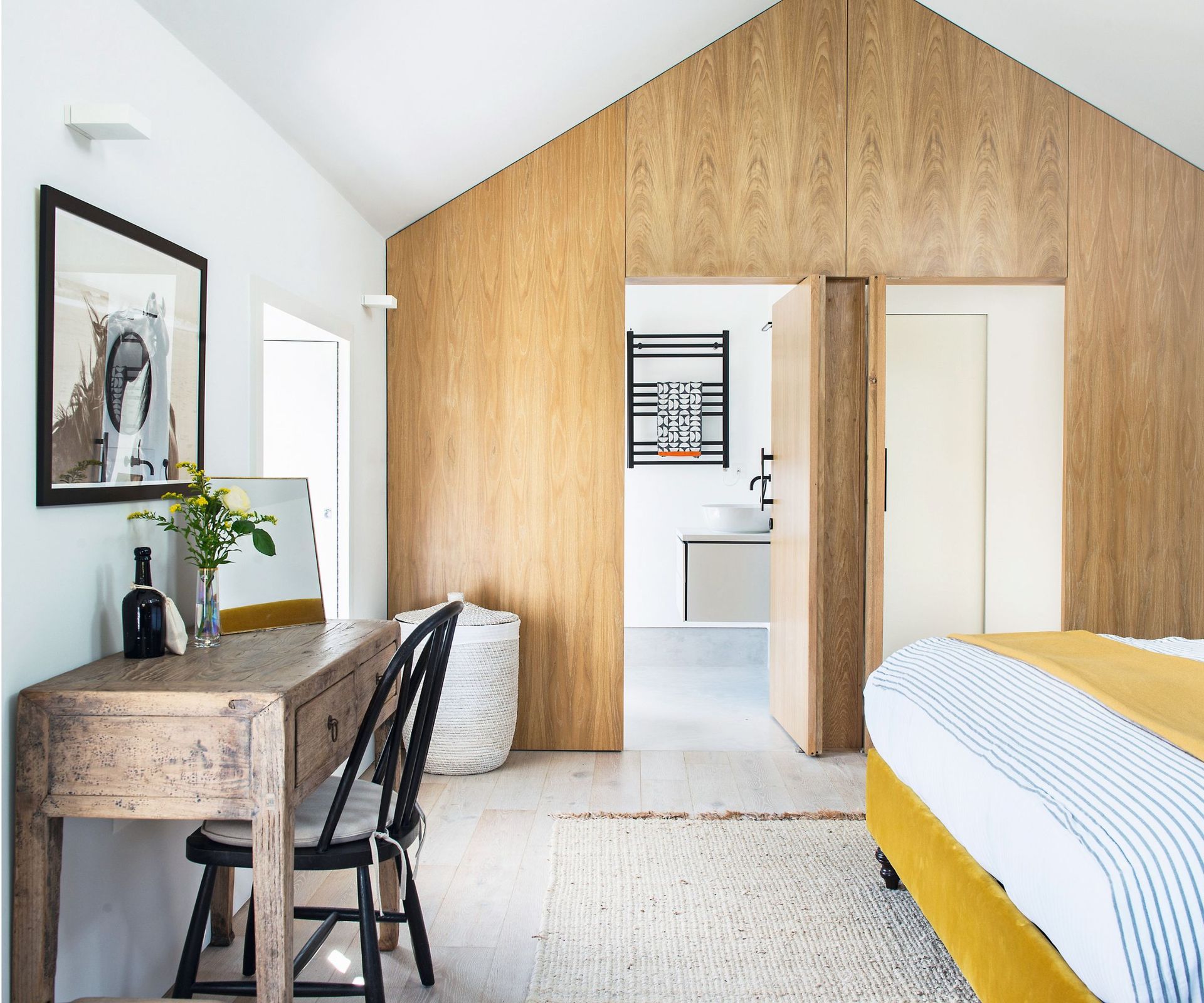 Wooden doors and desk, black chair, yellow bed