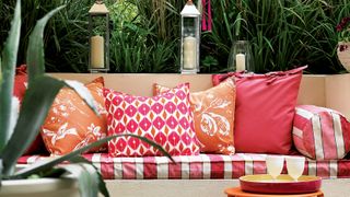 Terrace seating with red and orange cushions red and white striped fabric