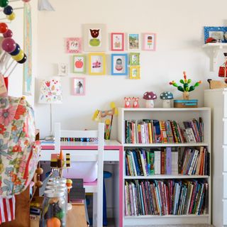 A kid's bedroom with a filled bookcase