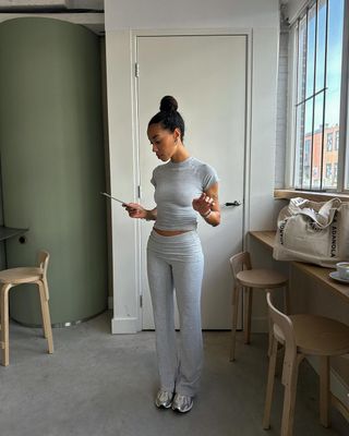 @amaka.hamelijnck wearing trainers with grey leggings and top