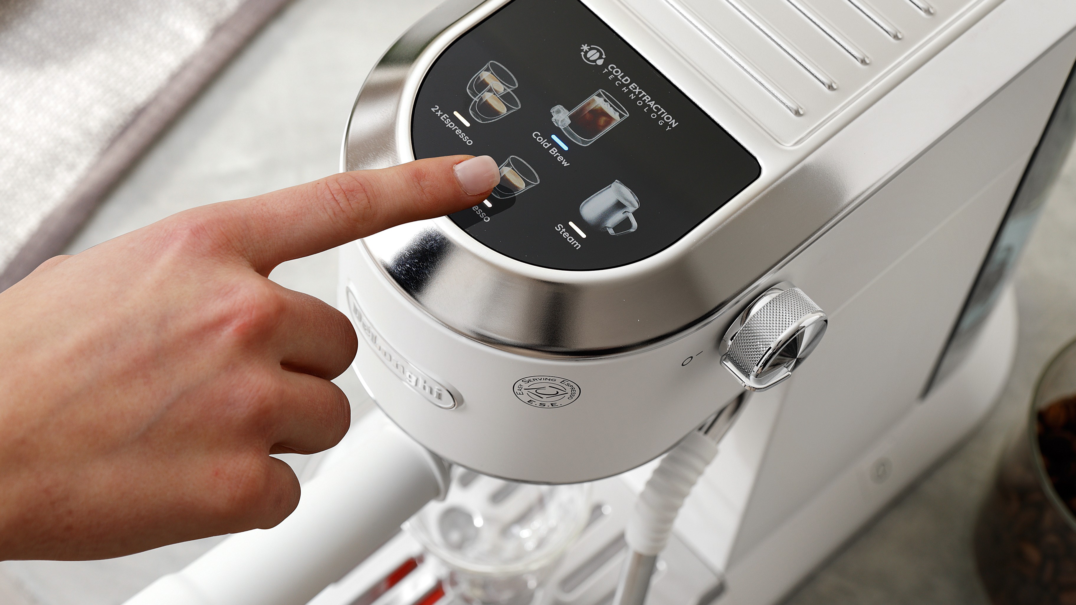 Person using control panel on top of De'Longhi Dedica Duo espresso machine