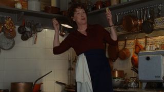 Meryl Streep, as Julia Child, cooks to her amusement in her '50s kitchen