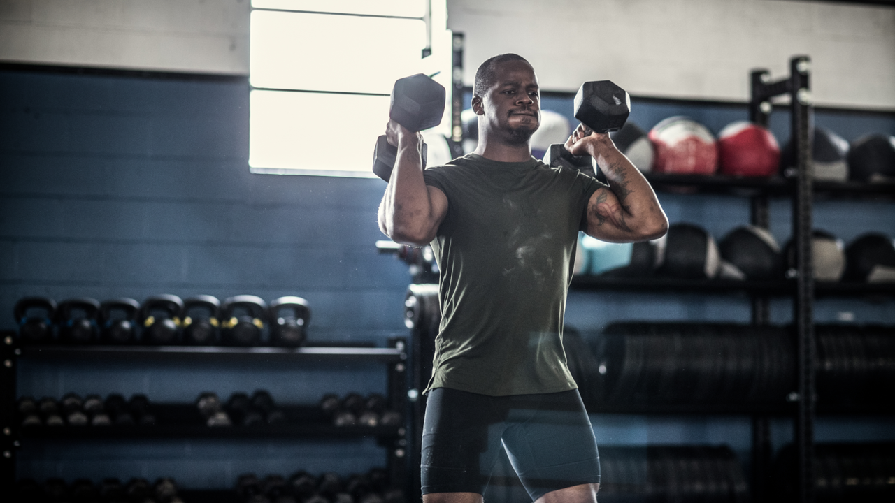 Man doing shoulder press with dumbbells