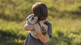 Boy cuddling puppy