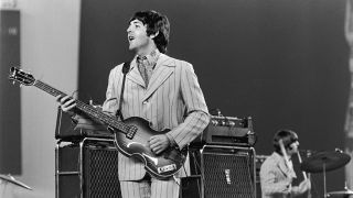 1966, British rock musician Paul McCartney playing on stage during The Beatles', last tour. Drummer Ringo Starr is visible in the background. 