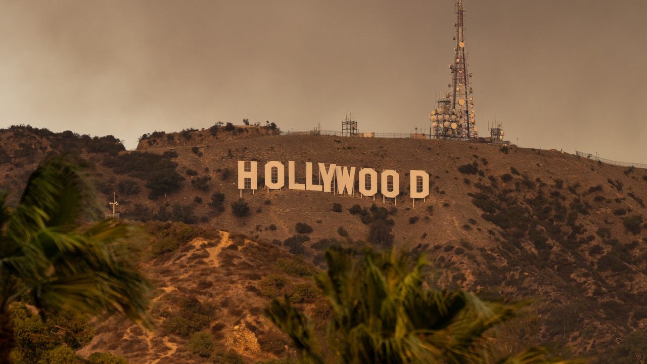 Smoke from multiple fires rises up behind the Hollywood sign in January 2025