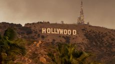 Smoke from multiple fires rises up behind the Hollywood sign in January 2025