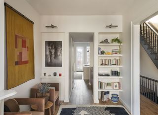 living room with white walls and bookcase around door frame