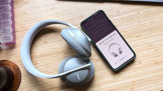 Bose 700 headphones with control app displayed on mobile device