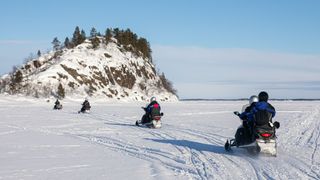 Take a snowmobile tour on the frozen lake of Inari