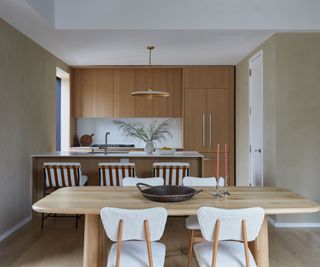 neutral kitchen with wooden dining table and boucle chairs