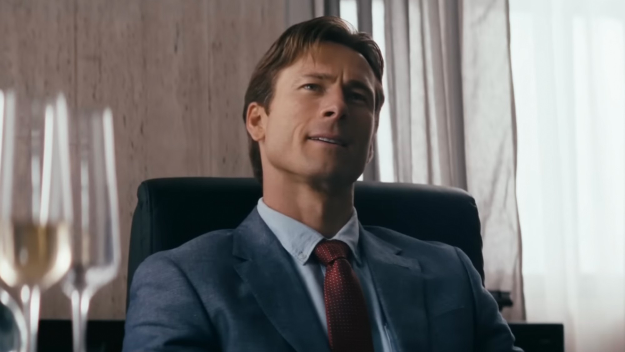 Glen Powell at a desk
