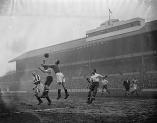 New Brighton's goalkeeper clears the ball from the head of Tottenham's Johnny Morrison during a game at White Hart Lane in January 1938.